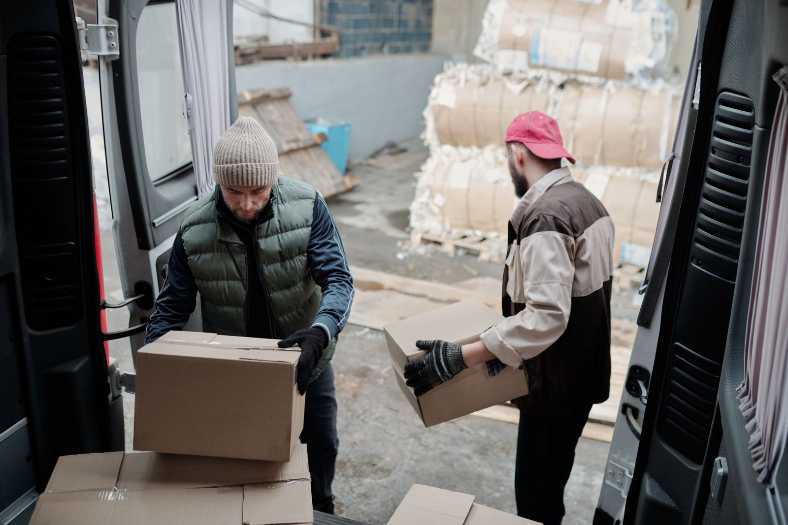 Two workers scanning boxes as they load a
                    delivery van at the loading dock